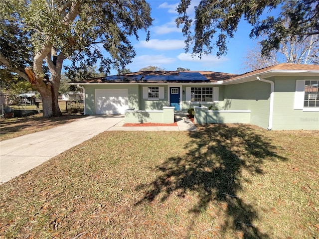 ranch-style house featuring a front yard, solar panels, and a garage