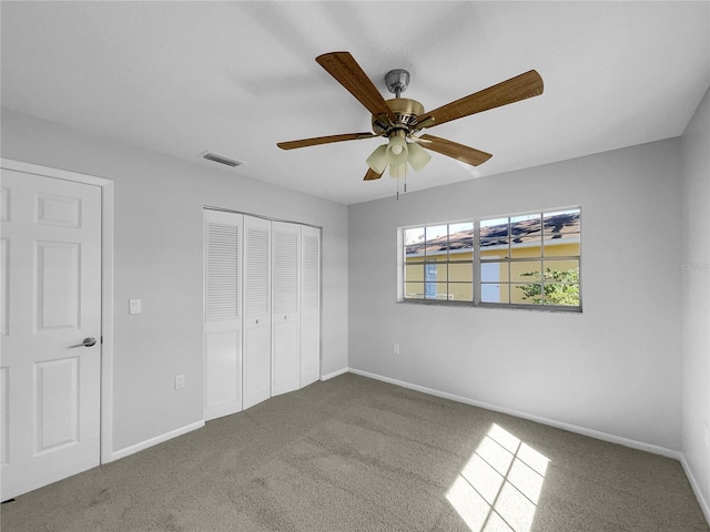 unfurnished bedroom featuring ceiling fan, a closet, and carpet