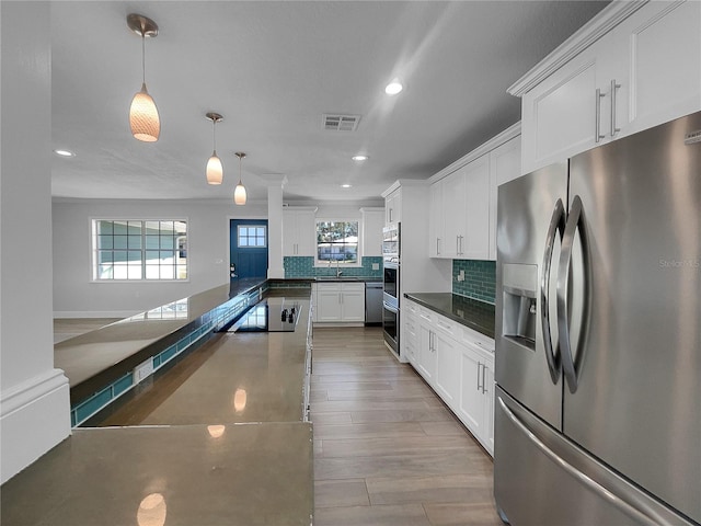 kitchen with white cabinetry, sink, stainless steel refrigerator with ice dispenser, backsplash, and decorative light fixtures