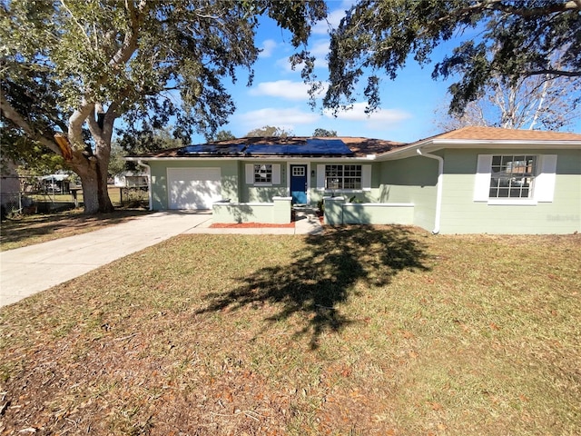 ranch-style home featuring a front yard, solar panels, and a garage