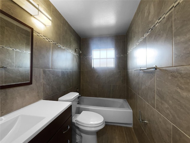 full bathroom featuring vanity, toilet, tile walls, and tiled shower / bath combo