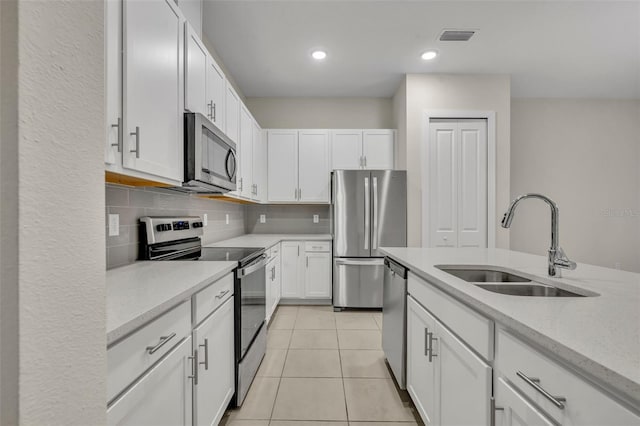 kitchen featuring light tile patterned flooring, sink, white cabinets, and stainless steel appliances