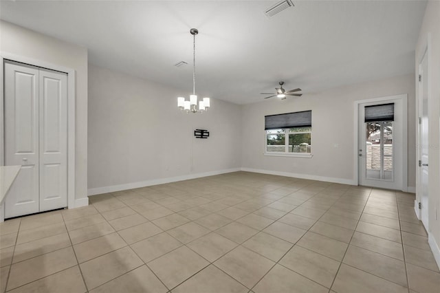 unfurnished dining area featuring light tile patterned floors and ceiling fan with notable chandelier