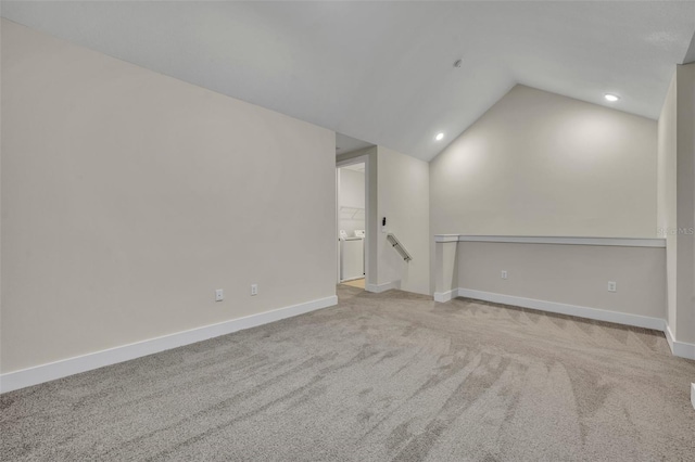 carpeted spare room with vaulted ceiling