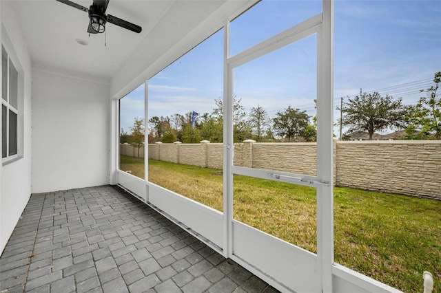 unfurnished sunroom featuring ceiling fan