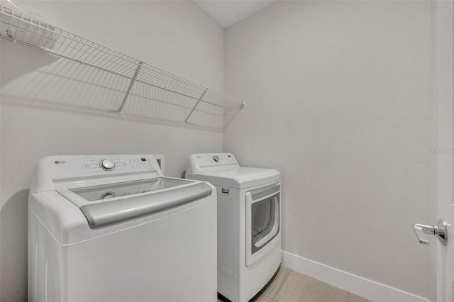 laundry area featuring separate washer and dryer and light tile patterned flooring