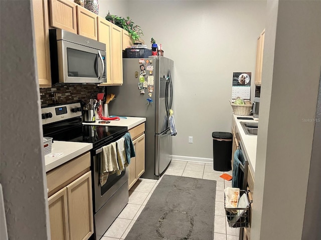 kitchen featuring stainless steel appliances, sink, light brown cabinets, light tile patterned flooring, and backsplash