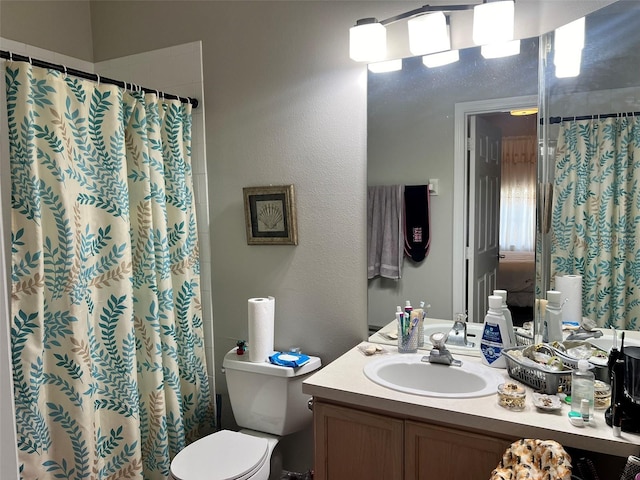 bathroom featuring curtained shower, vanity, and toilet