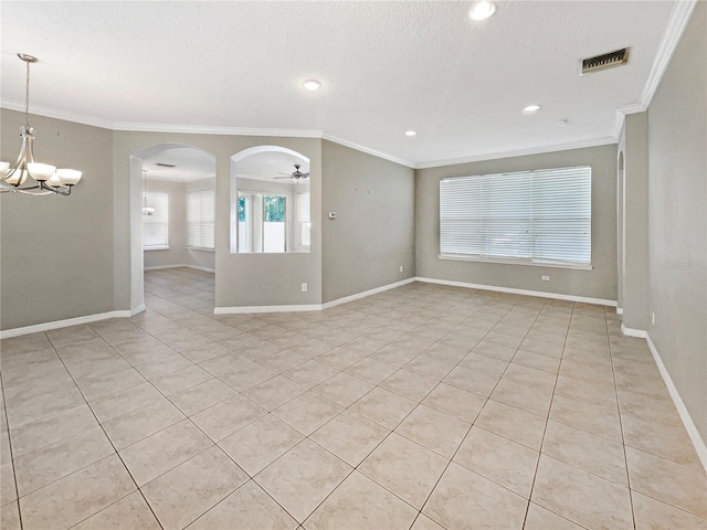 tiled empty room with a textured ceiling, ceiling fan with notable chandelier, and ornamental molding