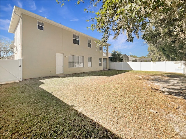 rear view of property featuring a yard