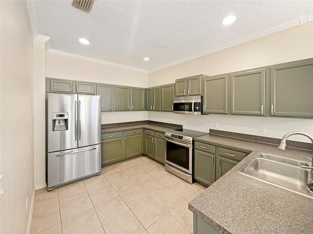 kitchen featuring appliances with stainless steel finishes, a textured ceiling, sink, light tile patterned floors, and green cabinetry