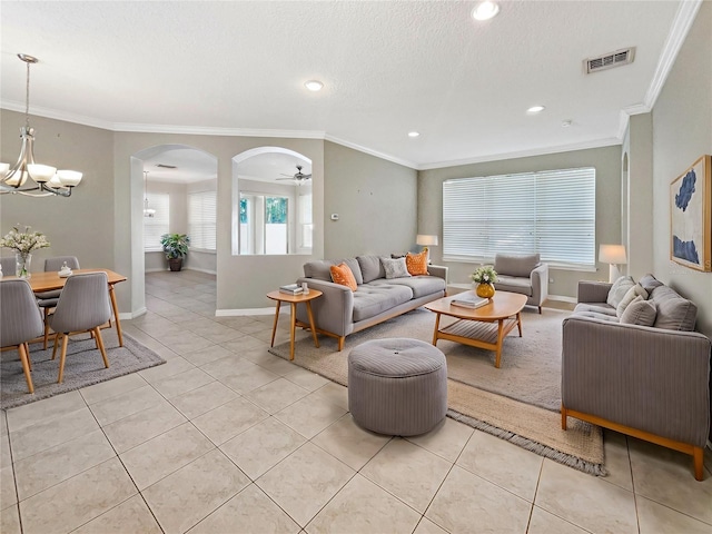 living room with light tile patterned floors, ceiling fan with notable chandelier, and crown molding