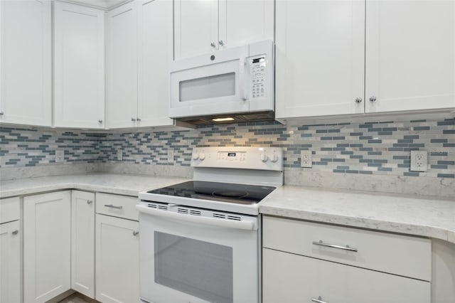 kitchen with decorative backsplash, white cabinetry, light stone countertops, and white appliances