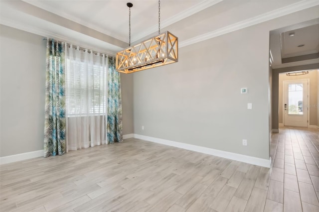 spare room with a notable chandelier, ornamental molding, and light hardwood / wood-style flooring