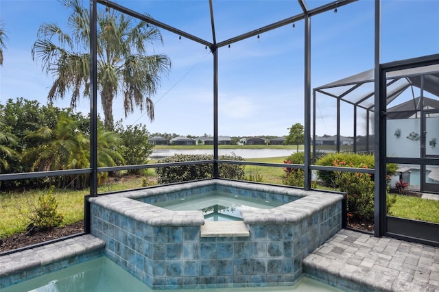 view of pool with glass enclosure, a water view, and an in ground hot tub