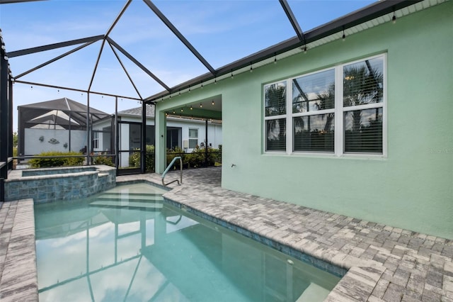 view of pool featuring glass enclosure, an in ground hot tub, and a patio