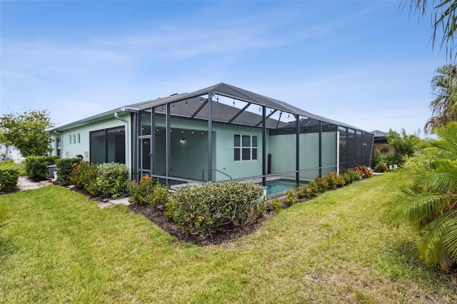 back of property with a lanai and a lawn