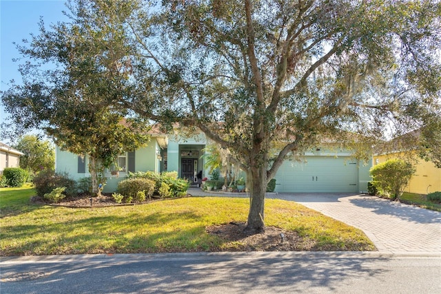 view of property hidden behind natural elements with a garage and a front lawn