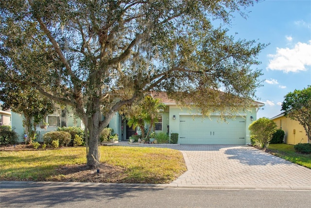 view of property hidden behind natural elements featuring a garage and a front lawn