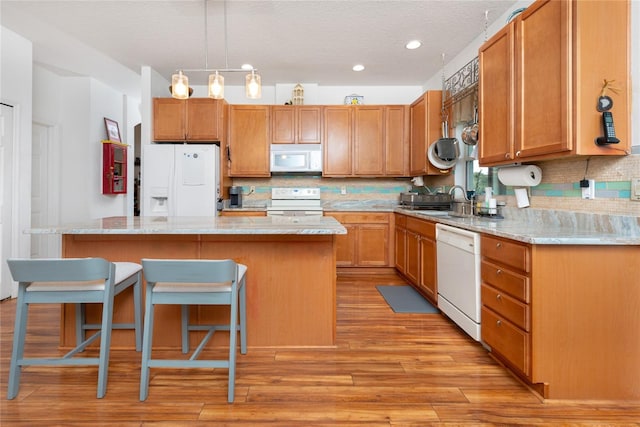 kitchen with a breakfast bar area, tasteful backsplash, a center island, and white appliances