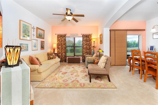 living room featuring light carpet, a wealth of natural light, and ceiling fan