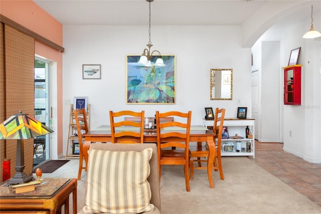 carpeted dining area featuring an inviting chandelier