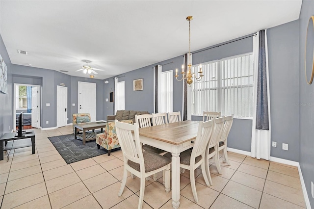 tiled dining space with ceiling fan with notable chandelier