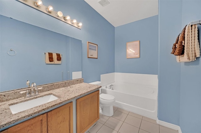 bathroom featuring toilet, vanity, tile patterned floors, and a bathing tub