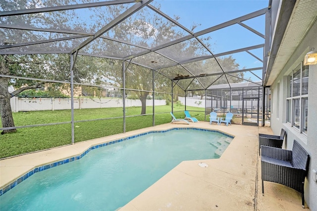 view of pool with glass enclosure, a yard, and a patio