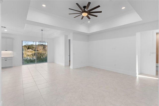 unfurnished room featuring a tray ceiling, ceiling fan, and crown molding