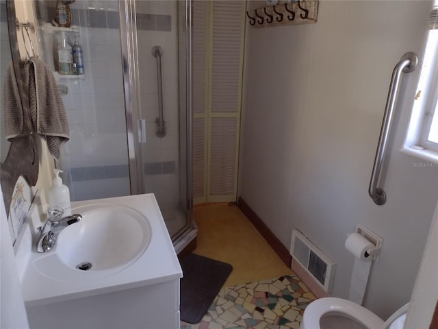 bathroom featuring tile patterned flooring, vanity, toilet, and walk in shower