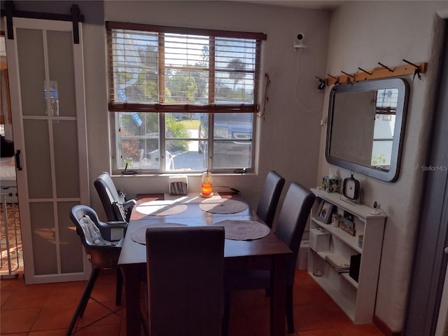 dining room featuring tile patterned flooring and a barn door