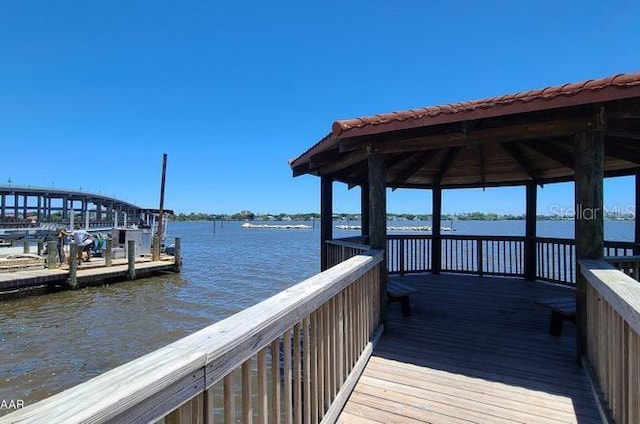 view of dock with a gazebo and a water view