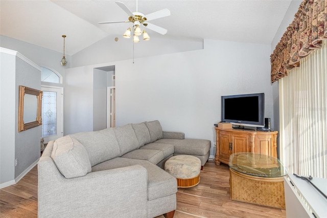 living room with ceiling fan, vaulted ceiling, and light hardwood / wood-style flooring