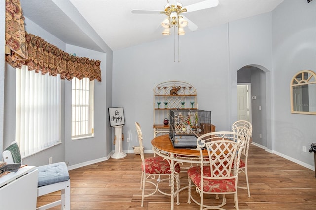 dining area with ceiling fan, lofted ceiling, and hardwood / wood-style floors