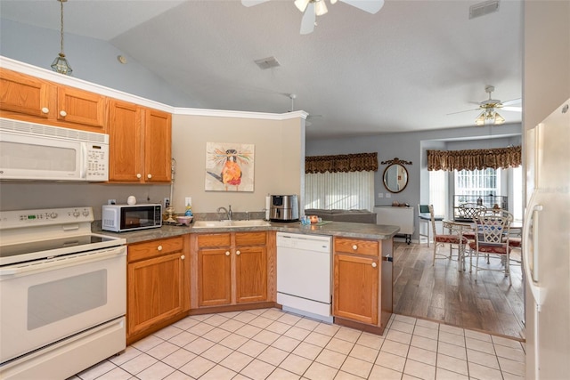 kitchen with light tile patterned flooring, sink, kitchen peninsula, and white appliances