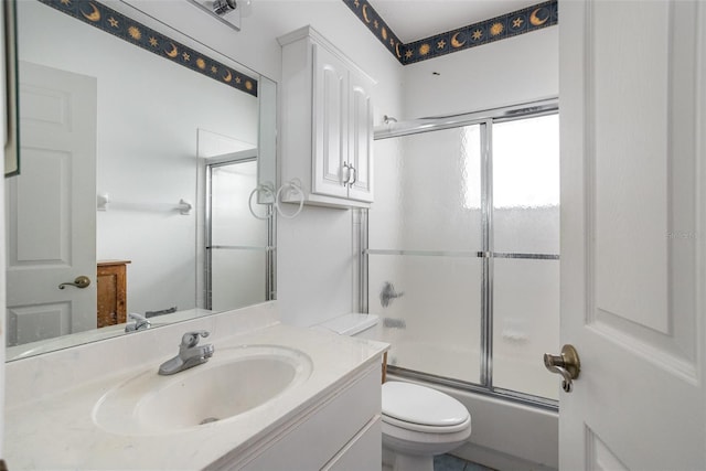 full bathroom with combined bath / shower with glass door, vanity, and toilet