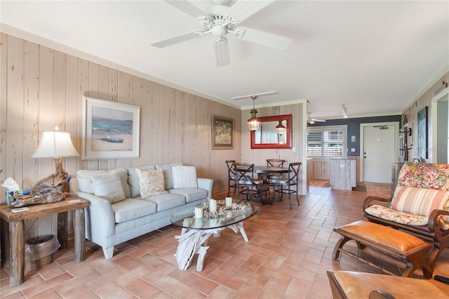 3663 S Atlantic Ave Unit 11D, New Smyrna Beach, FL 32169 - living room featuring ceiling fan, crown molding, and wooden walls