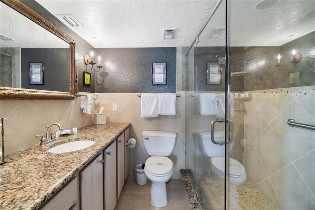 3663 S Atlantic Ave Unit 11D, New Smyrna Beach, FL 32169 - bathroom with walk in shower, vanity, toilet, and tile walls