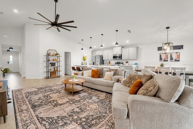 living room featuring ceiling fan, high vaulted ceiling, and light hardwood / wood-style floors