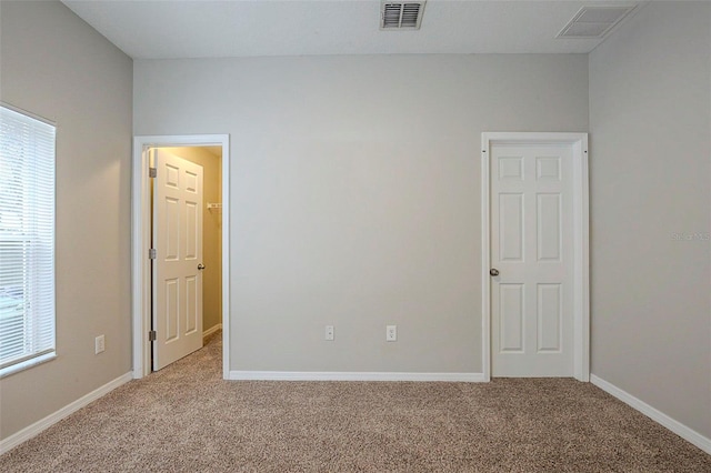 spare room featuring light carpet