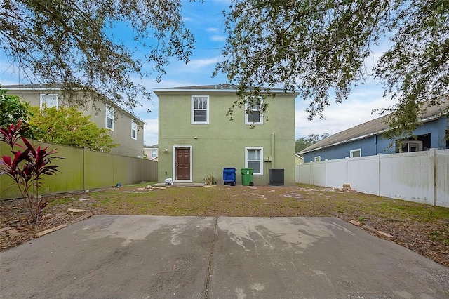 rear view of property with central AC unit and a patio