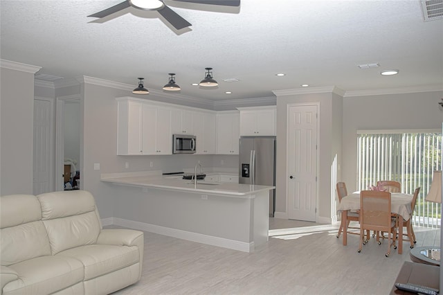 kitchen featuring white cabinetry, sink, stainless steel appliances, and ornamental molding