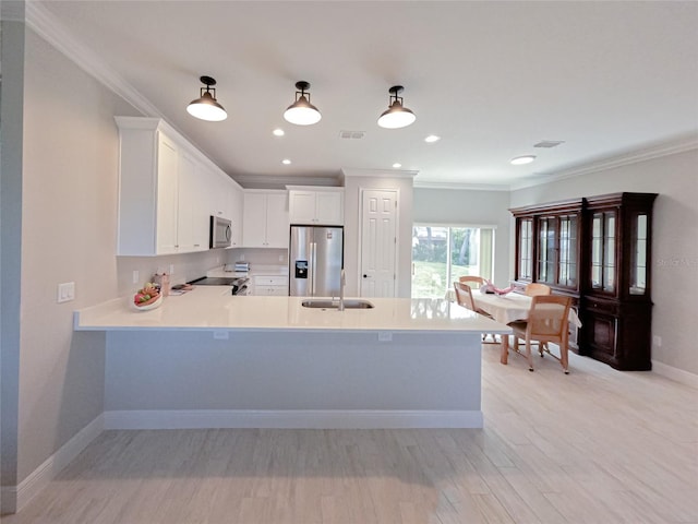 kitchen with white cabinets, stainless steel appliances, ornamental molding, and sink