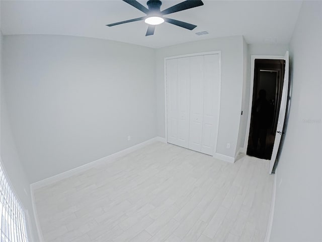 unfurnished bedroom with light wood-type flooring, a closet, and ceiling fan