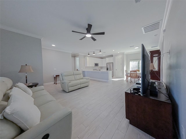 living room with ceiling fan and crown molding