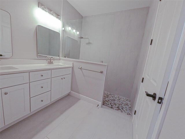 bathroom featuring a tile shower and vanity