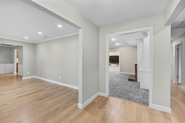 spare room featuring a textured ceiling and light hardwood / wood-style flooring