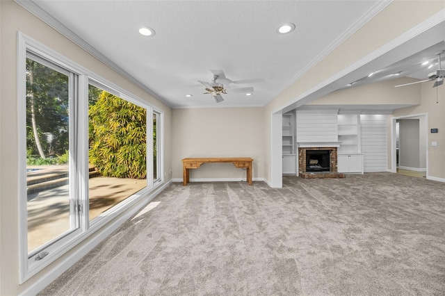 unfurnished living room with carpet, ceiling fan, ornamental molding, and a fireplace