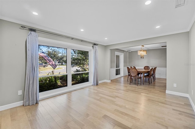 dining space featuring crown molding and light hardwood / wood-style floors